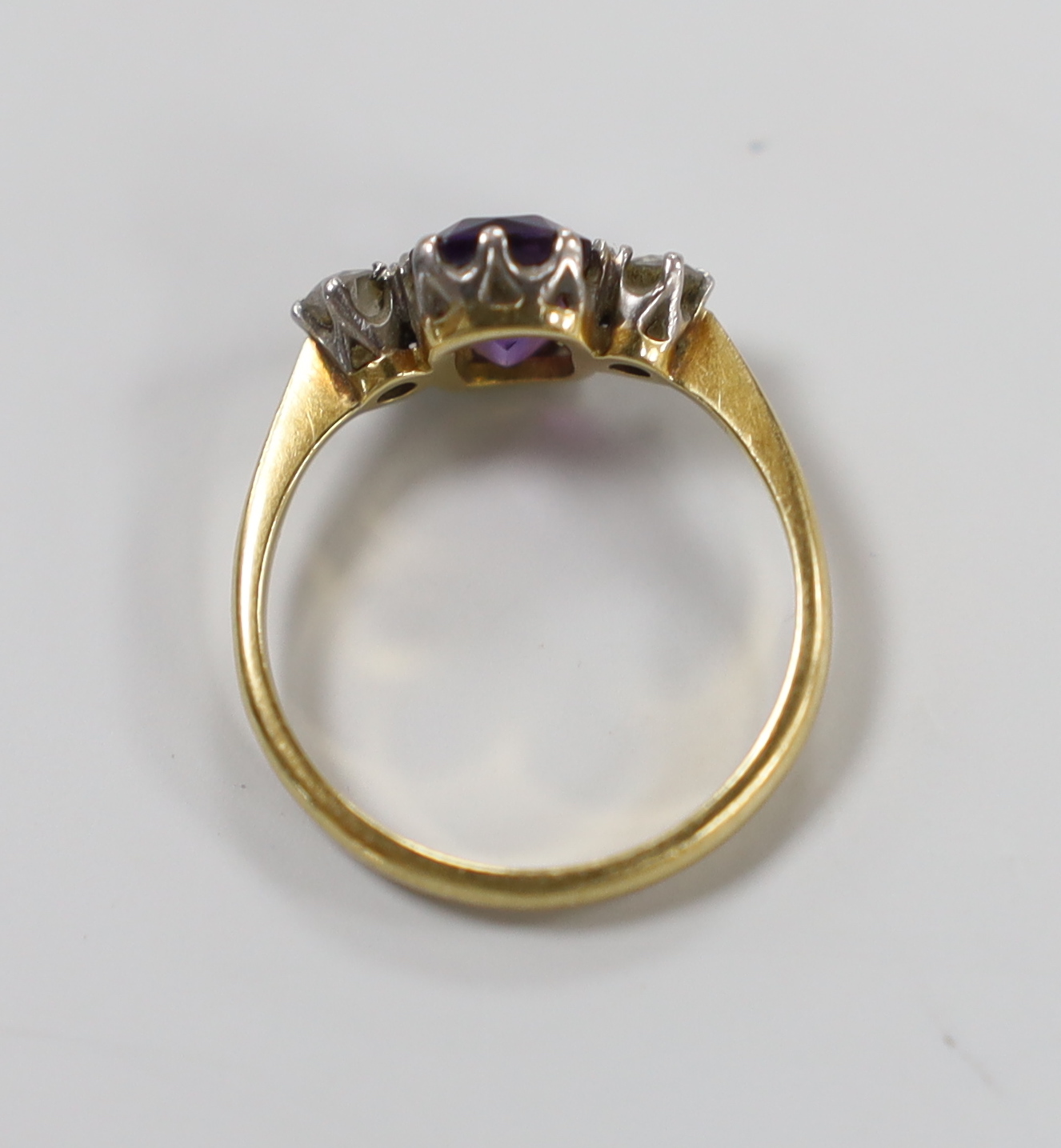 An 18ct, single stone amethyst and two stone diamond set ring, size N, gross weight 3 grams.